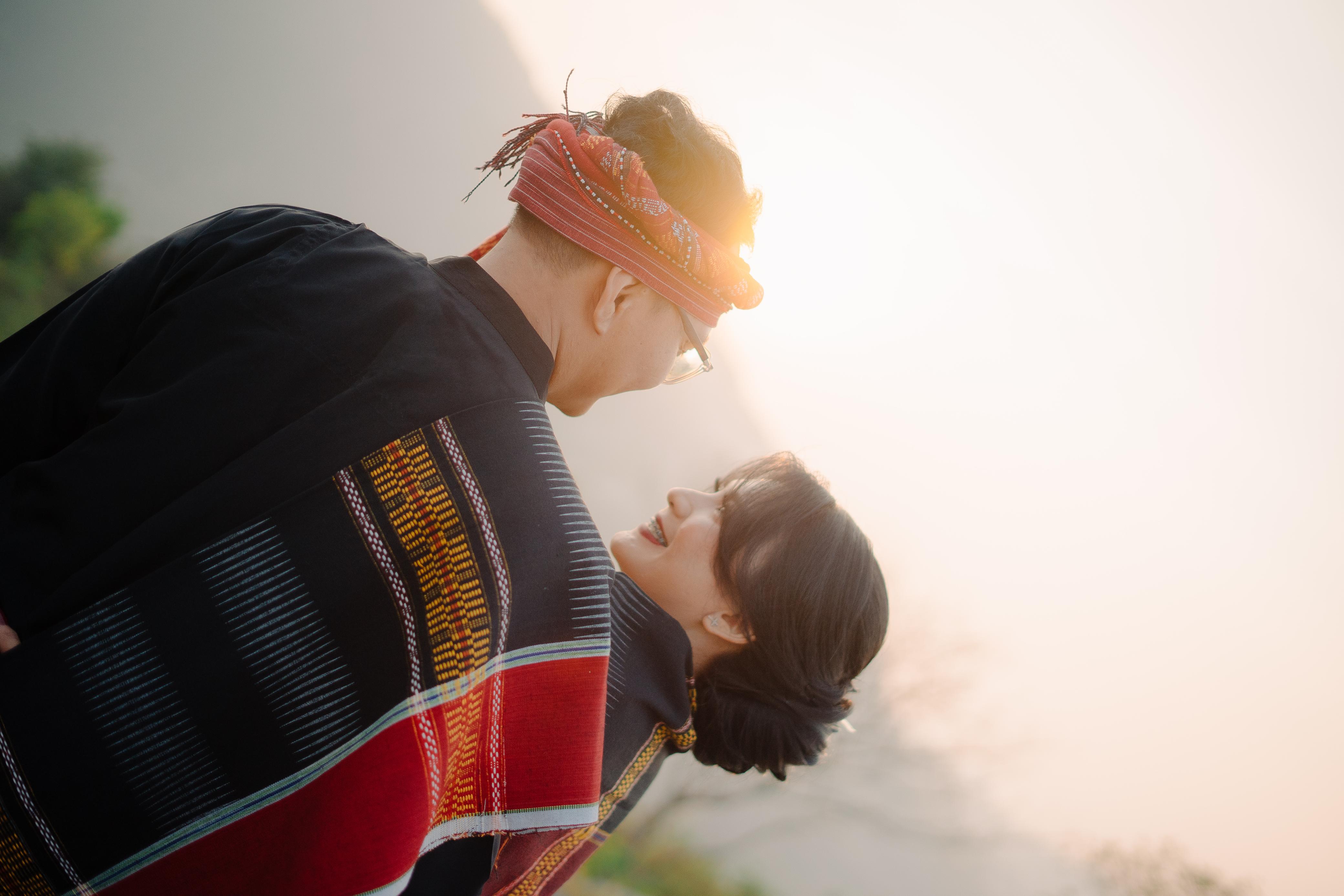 Pasangan pengantin dengan kain ulos saat matahari terbenam